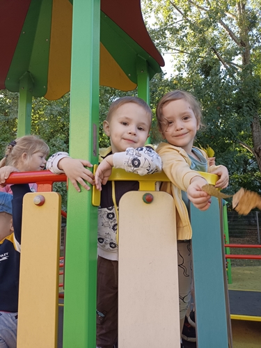 Dzieci stoją na konstrukcji placu zabaw