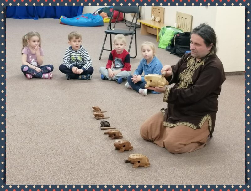 Pan Arek pokazuje dzieciom, w jaki sposób grać na "żabkach".