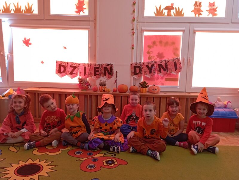 Na zdjęciu dzieci w strojach w kolorze pomarańczowym, niektóre przebrane w strój Dyni.