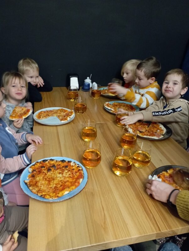 Na zdjęciu dzieci degustują wykonane przez siebie pyszne pizze.