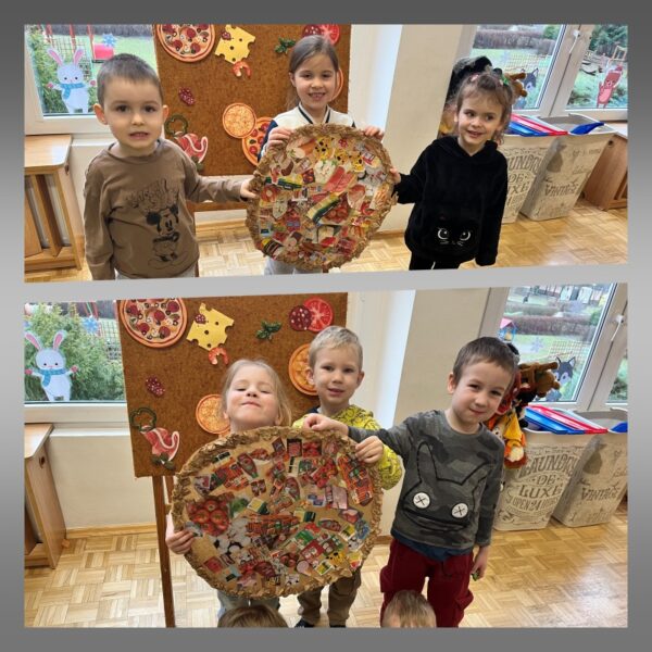 Dzieci z dumą i radością prezentują wykonaną wspólnie pizzę. Pozują na tle tablicy, na której umieściły na zajęciach wraz z nauczycielką poszczególne papierowe składniki, jakie mogą występować na pizzy.